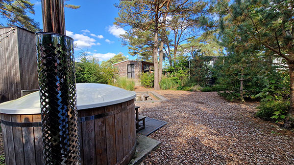 Tiny houses in een kring rondom een binnenplaats met hottub op EuroParcs De Zanding.