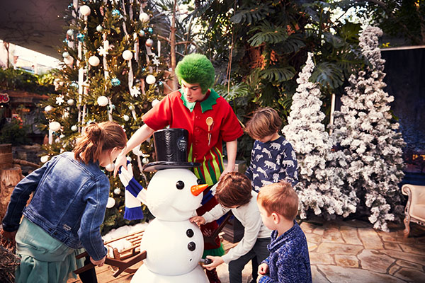 Orry met een gezin bij een sneeuwpop en kerstboom