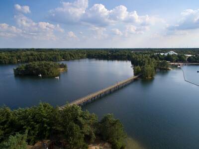 Luchtfoto van Center Parcs De Vossemeren met het parkmeer en loopbrug