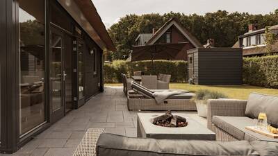 Loungeset en tuinmeubelen in de tuin van een vakantiehuis op Dutchen Villapark Mooi Schoorl