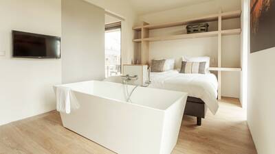 Slaapkamer met bad in een vakantiehuis op Dutchen Villapark Suitelodges Gooilanden