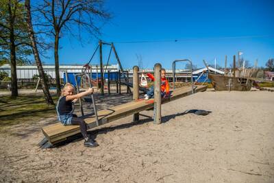 Kinderen op een wip in een speeltuin op vakantiepark EuroParcs Zuiderzee