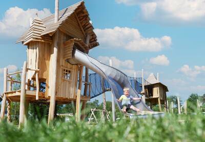Kind op een glijbaan in een speeltuin op vakantiepark Krieghuusbelten