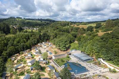 Luchtfoto van vakantiepark Roompot Parc la Clusure met het buitenbad en chalets