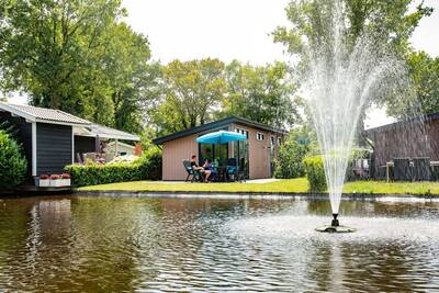 Lodges aan een vijver met fontein op vakantiepark Topparken Résidence De Leuvert