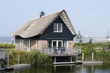 Luxe villa met terras boven het water op vakantiepark Beach Resort Makkum