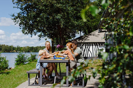 Gezin op het terras van een Jungalow "Zebra" op Lake Resort Beekse Bergen