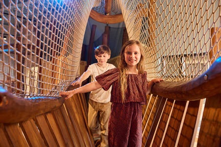 Kinderen op een touwbrug in de binnenspeeltuin (Kodidi Ground) van Safari Resort Beekse Bergen