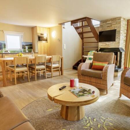 Woonkamer met eethoek en open haard van een vakantiewoning op Center Parcs Les Ardennes