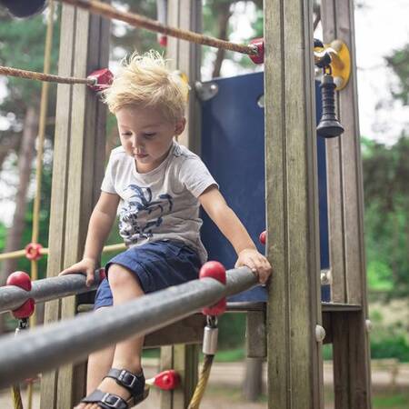 Een spelend kind in een speeltuin op Center Parcs Les Ardennes