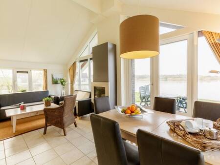 Woonkamer met eethoek en haard van een vakantiewoning op Center Parcs Parc Sandur