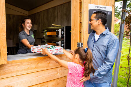 Vader en dochter kopen pizza's bij de Pizzahook op camping De Witte Berg