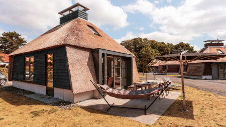 Tuin met hangmat en eettafel van een vakantiehuis op vakantiepark Dutchen Park Weideduyn