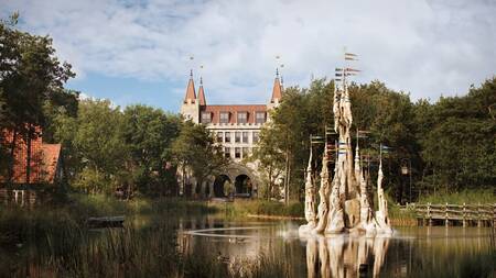 Zicht over het meer op het Poorthuys op vakantiepark Efteling Bosrijk