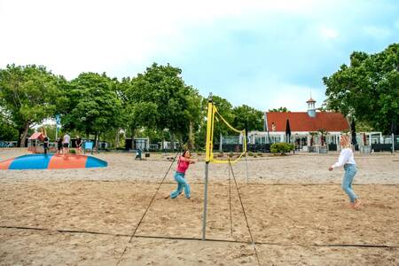 Mensen aan het volleyballen en kinderen op een airtrampoline op Europarcs Bad Hoophuizen