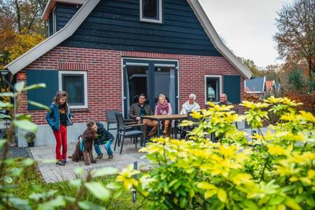 Mensen in de tuin van een vrijstaand vakantiehuis op vakantiepark EuroParcs De Hooge Veluwe