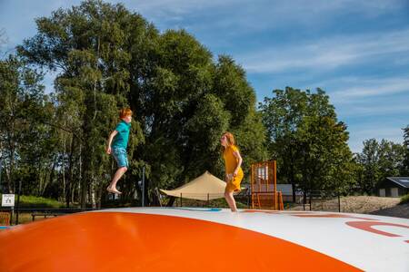Kinderen op een airtrampoline in de speeltuin op vakantiepark EuroParcs De IJssel Eilanden
