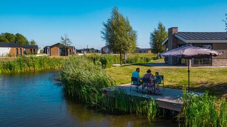 Gezin op een steiger bij een vakantiehuis op vakantiepark EuroParcs De IJssel Eilanden