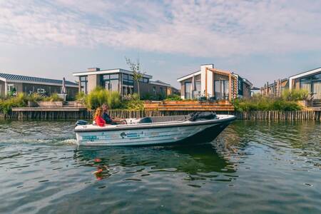 Stel in een sloep vaart voor vakantiehuizen op vakantiepark EuroParcs De Kraaijenbergse Plassen