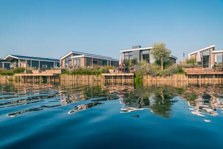 Chalets met steigers aan het water op vakantiepark EuroParcs De Kraaijenbergse Plassen