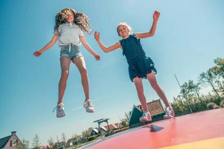 Kinderen springen op de airtrampoline op vakantiepark EuroParcs De Rijp