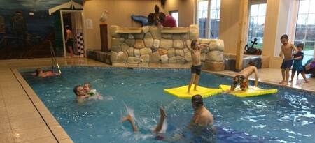 Mensen aan het zwemmen in het binnenbad op vakantiepark EuroParcs De Rijp