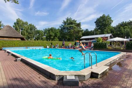Mensen aan het zwemmen in het buitenbad van vakantiepark EuroParcs De Wije Werelt