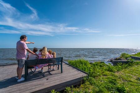 Gezin kijkt uit over het IJsselmeer op vakantiepark EuroParcs Enkhuizer Strand