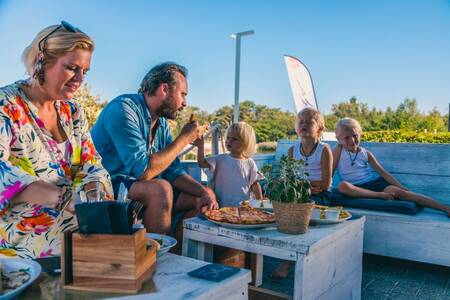 Gezin aan het eten op het terras van het restaurant op vakantiepark Europarcs EuroParcs Zilverstrand