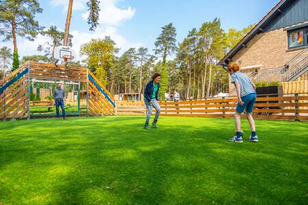 Gezin aan het voetballen op het multifunctionele speelveld op vakantiepark EuroParcs Hoge Kempen
