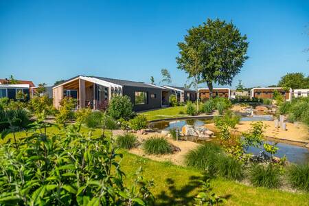 Chalets langs een sloot op vakantiepark EuroParcs Marina Strandbad