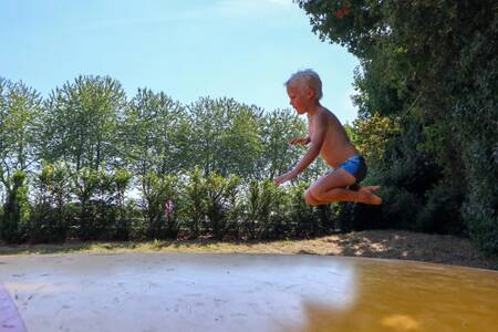 Kindje springt op de airtrampoline op vakantiepark EuroParcs Marina Strandbad