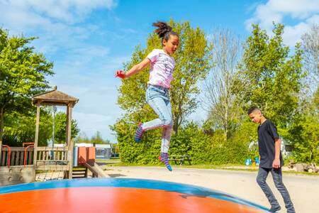 Kinderen springen op de airtrampoline in de speeltuin op vakantiepark EuroParcs Molengroet