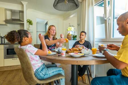 Gezin aan tafel in de keuken van een vakantiehuis op vakantiepark EuroParcs Molengroet