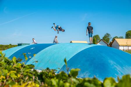 Kinderen springen op de airtrampoline op vakantiepark EuroParcs Poort van Maastricht