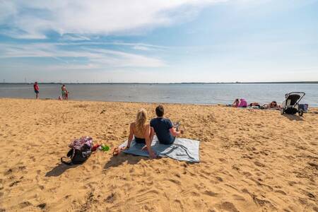 Mensen op het strand vlakbij vakantiepark EuroParcs Poort van Zeeland