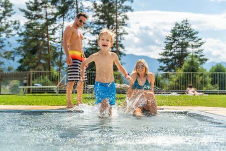 Gezin in het buitenbad van vakantiepark EuroParcs Pressegger See