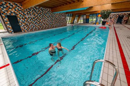 Paar aan het zwemmen in het binnenbad van vakantiepark EuroParcs Schoneveld