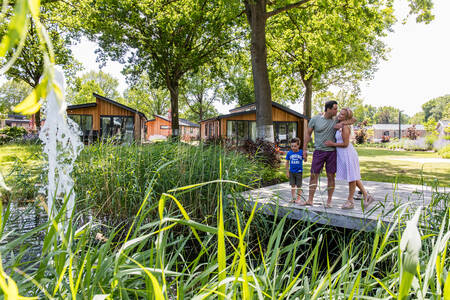 Een gezin op een steiger bij een vijver met fontein op EuroParcs Zuiderzee
