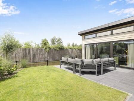 Loungeset in de tuin van een vakantiehuis op vakantiepark Familiehuis Nunspeet