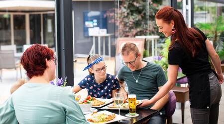 Gezin aan het eten in het restaurant van vakantiepark Recreatiepark t Gelloo