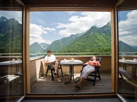 2 mensen ontspannen op het balkon van een appartement op Landal Alpen Chalet Matin