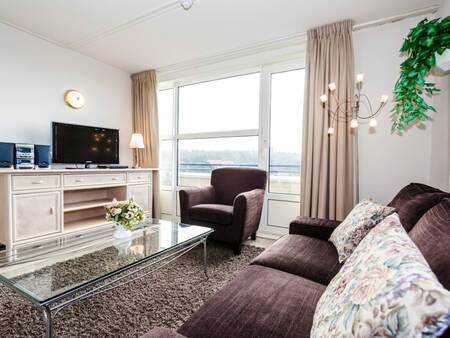 Woonkamer met grote ramen van een appartement op Landal Ameland State