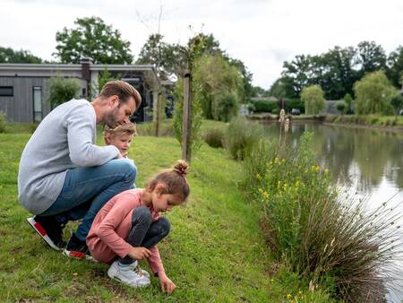 Gezin bij het water naast een vakantiehuis op vakantiepark Landal Amerongse Berg