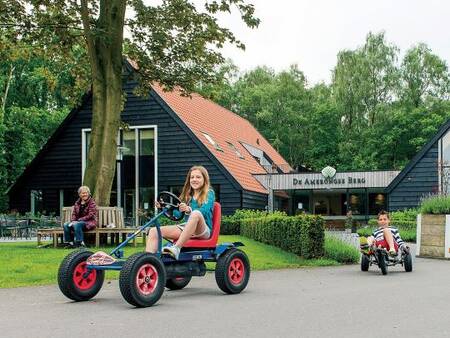 Kinderen op skelters op vakantiepark Landal Amerongse Berg