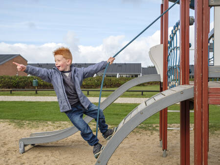 Kind speelt in de speeltuin op vakantiepark Landal Beach Park Grønhøj Strand