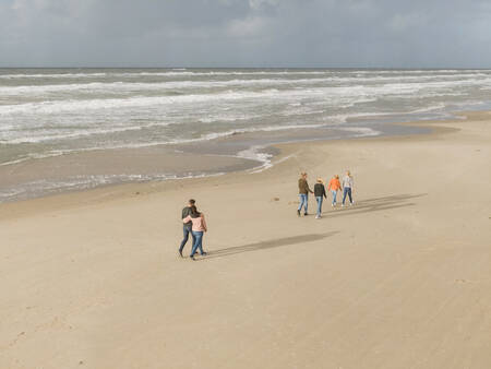 Mensen wandelen op het strand bij vakantiepark Landal Beach Park Grønhøj Strand