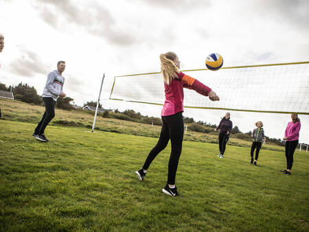 Mensen volleyballen op het volleybalveld van vakantiepark Landal Beach Park Grønhøj Strand