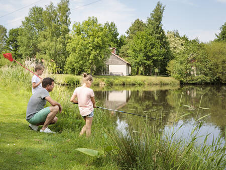 Een gezin is aan het vissen in het water van vakantiepark Landal De Bloemert