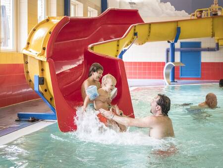 Kinderen glijden van de glijbaan in het zwembad van vakantiepark Landal De Hellendoornse Berg